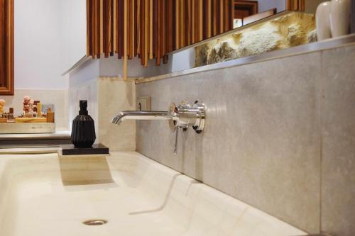 a sink in a bathroom with a faucet at Kel Domènech Luxury Apartment in Besalú
