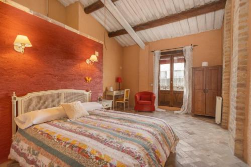 une chambre avec un lit et un mur rouge dans l'établissement La Festa Dels Sentits, Casa Rural, à Sant Martí de Maldá