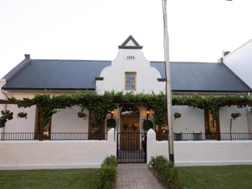 a white building with a black roof at Adderley House Guest Accommodation in Robertson