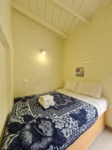 a bedroom with a bed with a blue and white blanket at Stefanos Garden3 in Arménoi