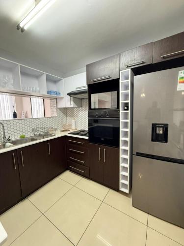 a kitchen with brown cabinets and a stainless steel refrigerator at Haven Luxury Apartment in Windhoek