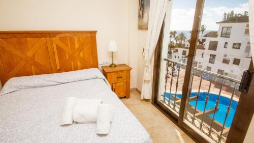 una camera con letto e vista sulla piscina di Marina Real 0245 a Castillo de Sabinillas