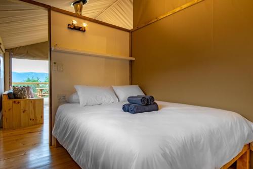 a bedroom with a large white bed in a room at AfriCamps at White Elephant Safaris in Pongola Game Reserve
