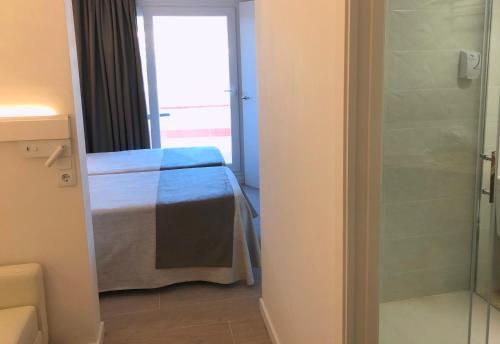 a bedroom with a bed and a glass shower at Hotel Medium Claramar in Platja  d'Aro