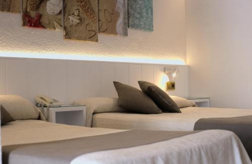 a room with two beds with pillows on them at Hotel Medium Claramar in Platja  d'Aro