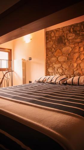 a bed in a room with a stone wall at Piccola casa vacanze - Small vacation house in Porto Valtravaglia