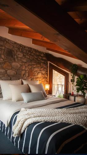 a bedroom with a large bed with a stone wall at Piccola casa vacanze - Small vacation house in Porto Valtravaglia