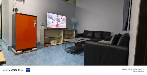 un soggiorno con un divano e una TV di Jatuporn a Betong