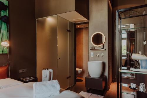 ナイメーヘンにあるBoutique Hotel Blue - Quality Lodgingsのベッドとバスルームがあるホテルの部屋