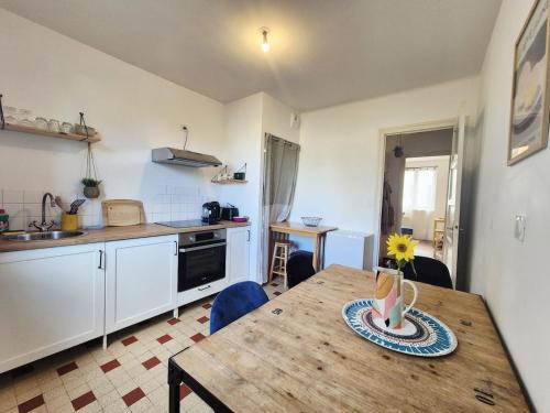 una cocina con una mesa de madera en una cocina con una mesa sidx sidx en Parenthèse à l'Oasis, en Ploërmel