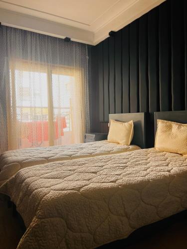 um quarto com duas camas e uma janela em Corniche Apartments em Casablanca