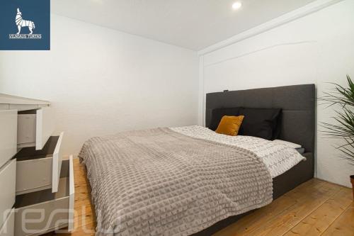 a bedroom with a bed in a white room at Loftas Dumu fabrikas in Vilnius