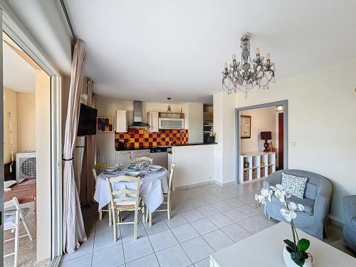 een woonkamer en een keuken met een tafel en stoelen bij Nice family apartment close to the beach in Le Lavandou