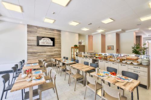 a restaurant with wooden tables and chairs and a buffet at Hotel Tre Ville in Parma