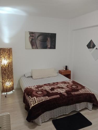 a bedroom with a bed with a blanket on it at Alojamiento K&A in Torrent