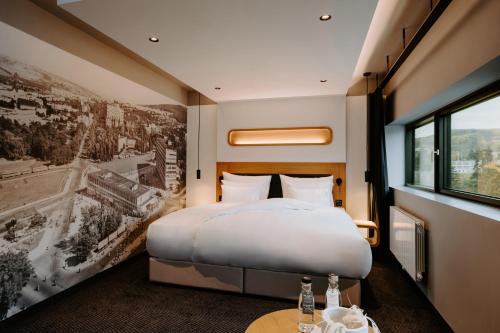 a hotel room with a bed and a poster of a city at Hotel Prior & Energy Spa in Zlín