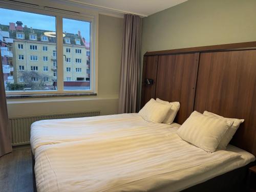 ein Schlafzimmer mit einem großen Bett mit einem großen Fenster in der Unterkunft City Central Hotel Örebro by First Hotels in Örebro