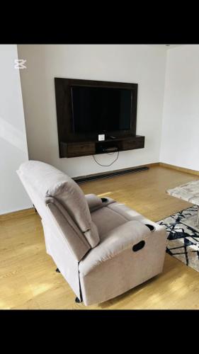 a brown chair in a living room with a tv at Shalom Apartment in Lusaka