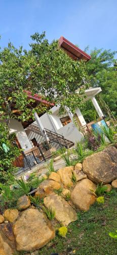a group of chairs and rocks in front of a house at Cinnamon garden villa ahangama in Ahangama
