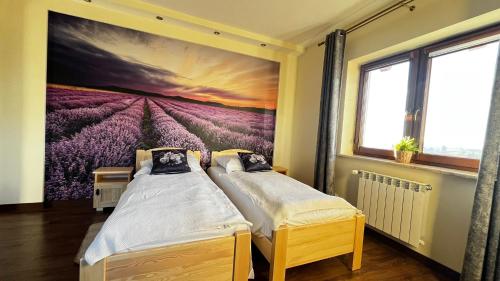 two beds in a room with a painting on the wall at Willa Sulejowka in Poronin