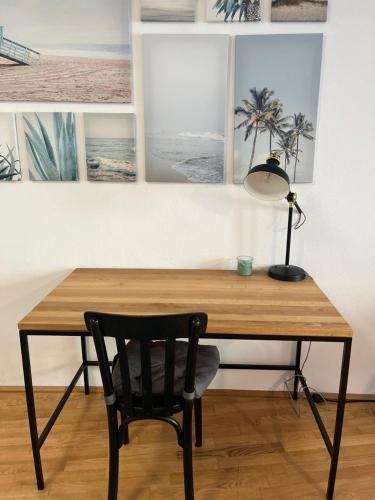 a desk with a chair and a lamp and pictures at Studios Harrachgasse FIVE in Graz