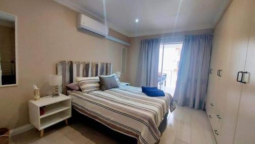 Un dormitorio con una cama grande y una ventana en Perfect holiday destination!, en Jeffreys Bay