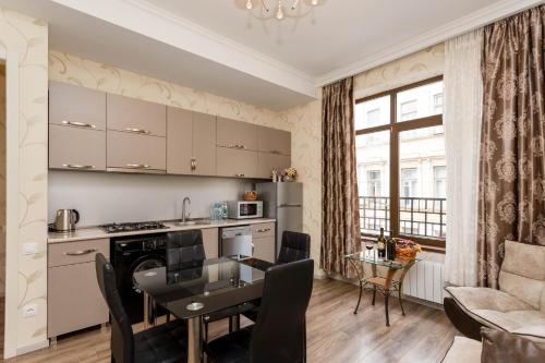 a kitchen and living room with a table and a dining room at Comfort retreat in Tbilisi City