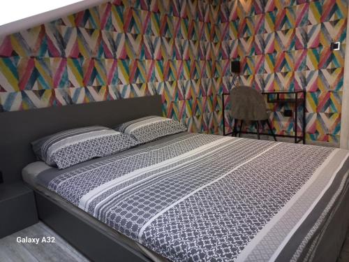 a bedroom with a bed and a colorful wall at New Grey in Novi Beograd