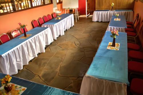 a row of blue tables in a room with red chairs at Pine Breeze Getaway LUKENYA in Athi River