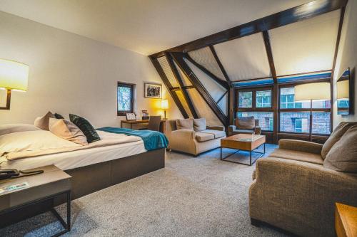 a bedroom with a large bed and a living room at Great Polonia The Granary La Suite Hotel in Wrocław