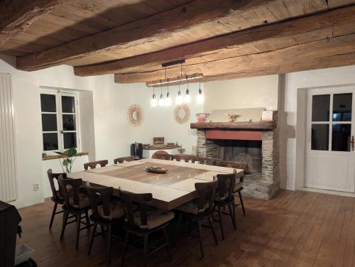 Un comedor con mesa y chimenea. en Saisonnée, en Centrès