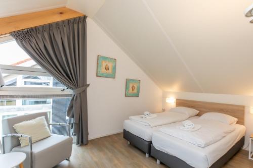 two beds in a room with a window at Zonnedorp 18 Duinhuis Renesse | Relaxte strandvakantie voor het hele gezin in Renesse