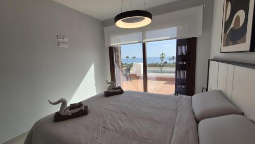 a bedroom with a bed with a view of the ocean at Casa Reinolds in El Pozo del Esparto