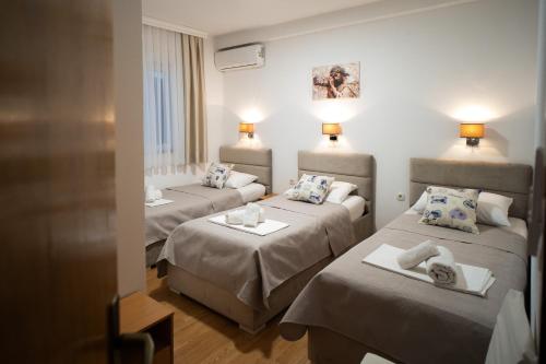 a hotel room with three beds and a couch at Pansion Milena i Mario in Međugorje