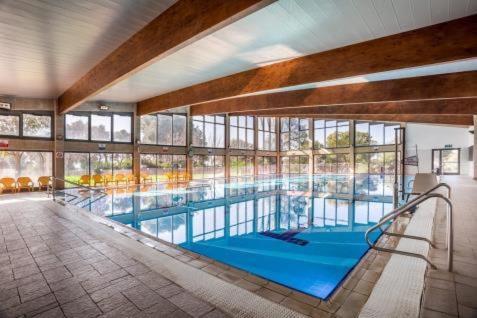 a large swimming pool in a large building at Lavi Kibbutz Hotel in Lavi