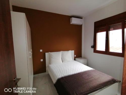 ein Schlafzimmer mit einem Bett und einem Fenster in der Unterkunft Villa Anastasia 1ος Όροφος Εξοχικής Παραθαλάσσιας Κατοικίας Νέα Ηράκλεια Χαλκιδικής in Nea Iraklia