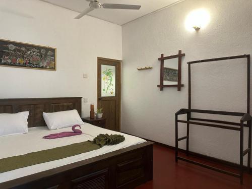 een slaapkamer met een bed met een roze lint erop bij Surf Dine in Matara
