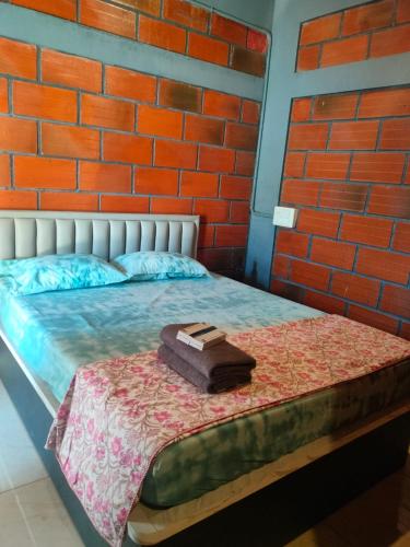 a bed with a briefcase sitting on top of it at Rustic Roots Inn in Jāmb