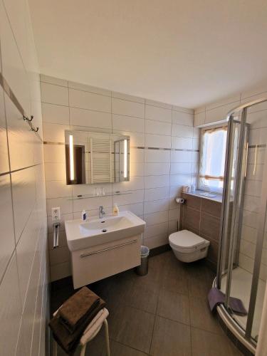 a white bathroom with a sink and a toilet at Gästehaus Truskaller in Mallnitz