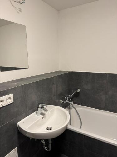 a bathroom with a sink and a bath tub at Wunderschöne Maisonette Ferienwohnung in Leipzig Taucha 2 u 3 OG Mitte in Taucha