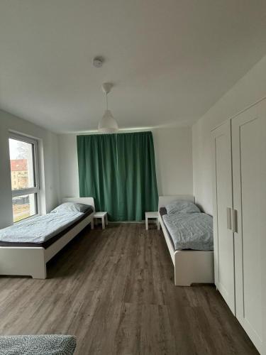 a bedroom with two beds and a green curtain at Wunderschöne Maisonette Ferienwohnung in Leipzig Taucha 2 u 3 OG Mitte in Taucha