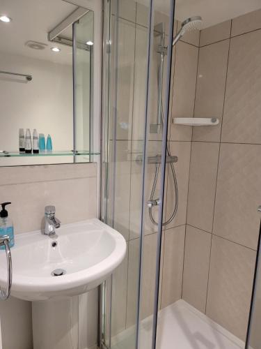 a bathroom with a sink and a shower at Atlantic Seafront in Brighton & Hove