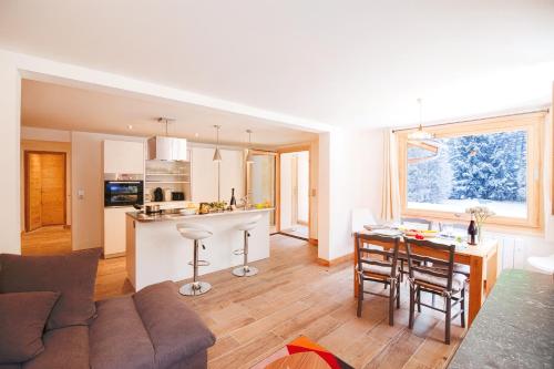 een woonkamer en keuken met een bank en een tafel bij Appartement La Creusettaz Happy Rentals in Chamonix-Mont-Blanc