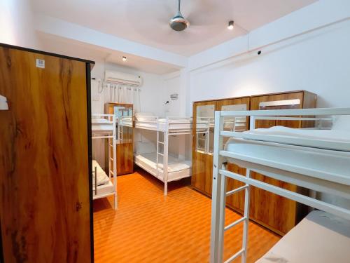a room with three bunk beds and a hallway at HOSHTEL99 - PRIME - Stay, Cowork & Connect in Pune