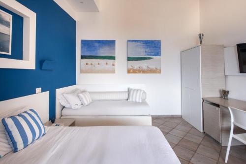 a bedroom with a white bed and a blue wall at Da Nino sul mare Filicudi in Filicudi