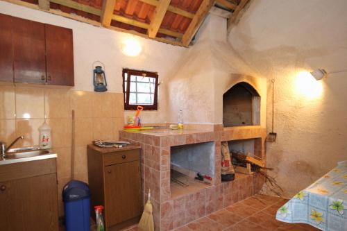 GrudaにあるHoliday house with a swimming pool Dubravka, Dubrovnik - 9101のキッチン(中央にレンガ造りのオーブン付)