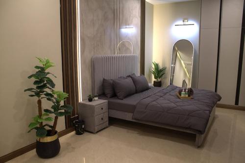 a bedroom with a bed with a mirror and a table at Spacious Studio with UPS, across Giga mall, Pool included in Islamabad