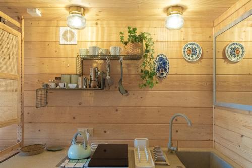 a kitchen with wooden walls and a sink at Alemiło mini - domek z balią i widokiem na Babią Górę in Zawoja