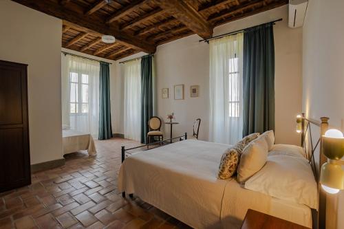 a bedroom with a large bed and two windows at Casale Malatesta in Velletri