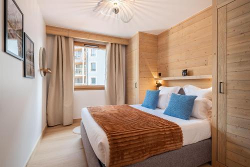 于埃Apartment Vira Alpe d'Huez - by EMERALD STAY的卧室里有一张大床，配有蓝色枕头